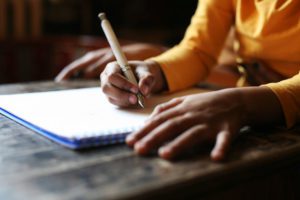 A person writing on a notepad image for handwritten wills explained blog