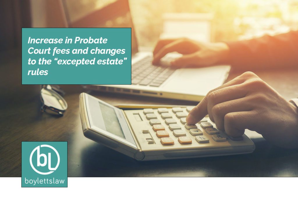 Hands using calculator and laptop image for increase in probate court fees and changes to the excepted estate rules blog