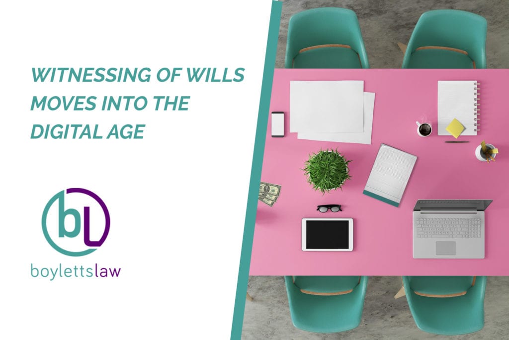 Image of a tablet and a laptop on pink meeting room table for blog about witnessing of wills moves into the digital age