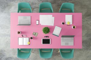 Image of a tablet and a laptop on pink meeting room table for Witnessing of wills moves into the digital age blog
